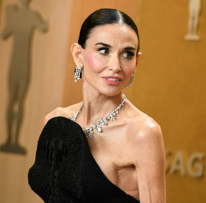 Demi Moore on the red carpet showcasing her latest beauty standard transformation with elegant jewelry and sleek hairstyle.