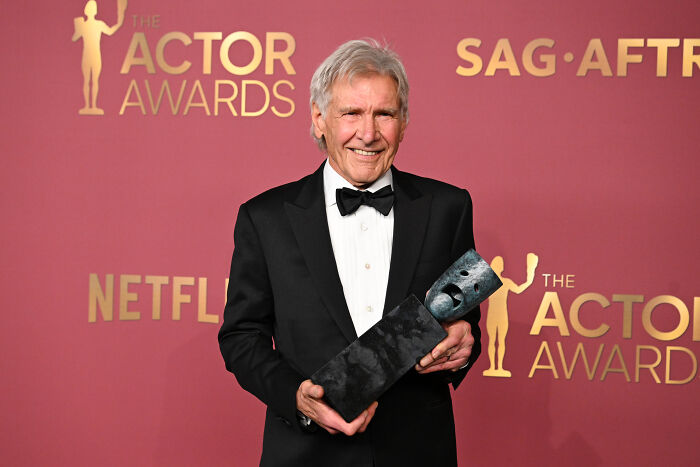 Harrison Ford holding an award at the Actor Awards event, surprising fans with his decision to keep acting. Harrison Ford holding an award at the Actor Awards event, surprising fans with his decision to keep acting.