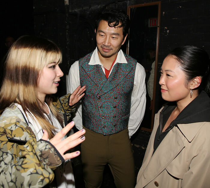 Three people in casual attire engaged in conversation, relating to Alysa Liu's childhood and championship withdrawal.