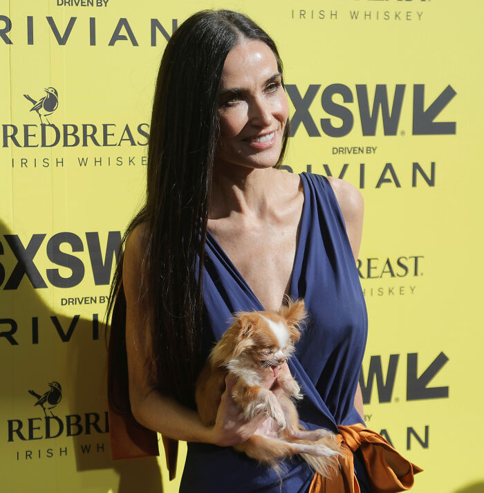Demi Moore at SXSW event holding a small dog, sparking discussion amid concern over her weight loss.