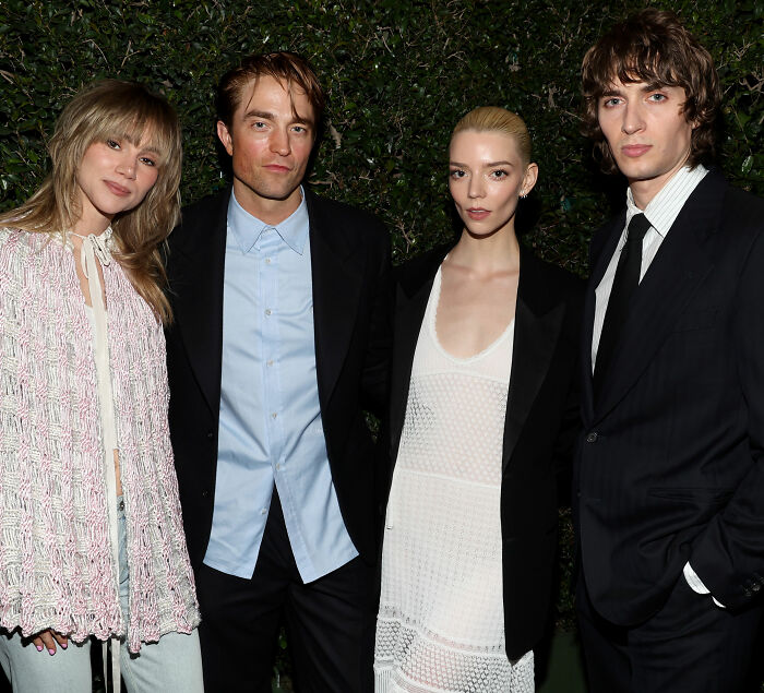 Anya Taylor-Joy in a white dress and black blazer with three others at a nighttime event, sparking fan debate.