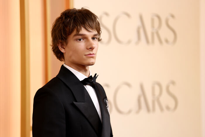 Young man in a tuxedo at the Oscars event, capturing the essence of Mckenna Grace stealing the show moment. Young man in a tuxedo at the Oscars event, capturing the essence of Mckenna Grace stealing the show moment.