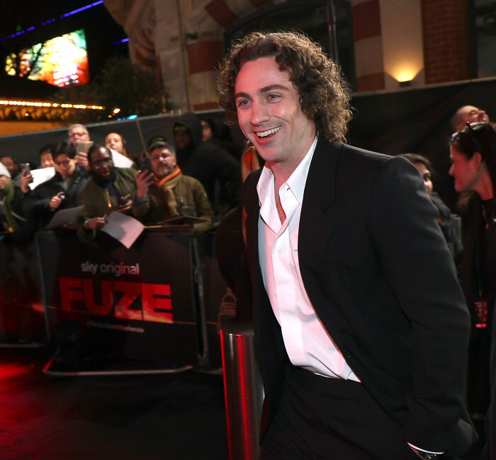 Aaron Taylor-Johnson at red carpet event, with fans in background noting odd changes in his evolved form appearance. Aaron Taylor-Johnson at red carpet event, with fans in background noting odd changes in his evolved form appearance.
