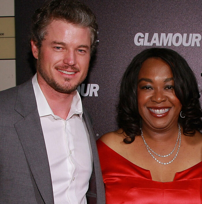 Shonda Rhimes and Eric Dane smiling at a Glamour event, discussing Oscars In Memoriam tribute controversy.