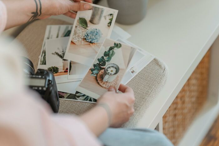 Person holding printed photos with nature scenes, relating to guess the hidden word from two picture clues.