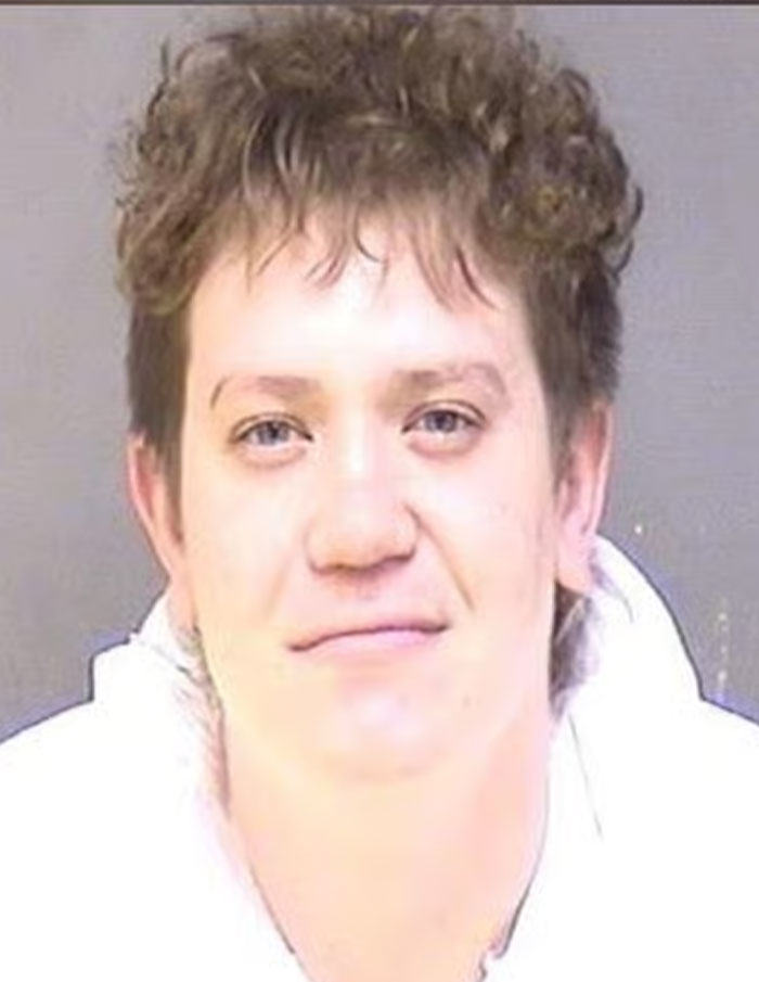 Mugshot of a man accused of slaying a passenger and driving off with the body, involved in a wild crime story.