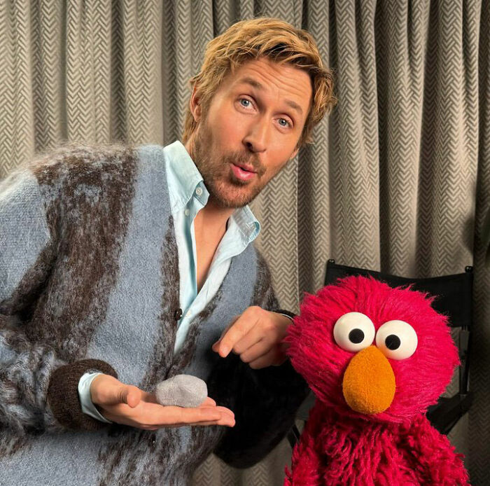 Ryan Gosling at a premiere event posing with Elmo, sparking fan speculation over his injector and appearance.
