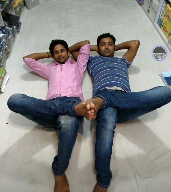 Two men lying on the floor pulling off a creative pose with their legs intertwined, showcasing hilarious and creative poses.