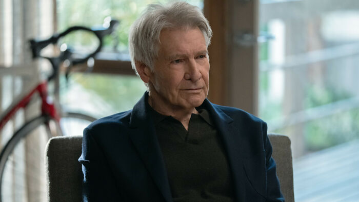 Harrison Ford seated indoors, appearing emotional during a tearful speech about continuing his acting career. Harrison Ford seated indoors, appearing emotional during a tearful speech about continuing his acting career.