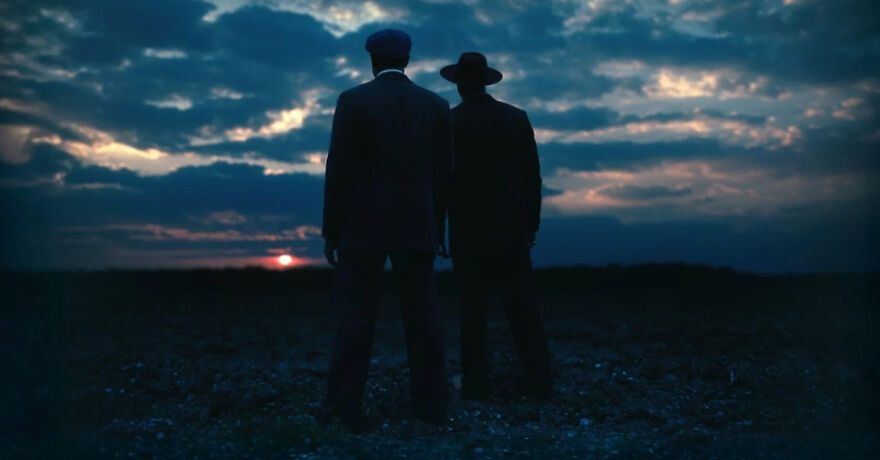 Two men in hats stand in a dark field at sunset, showcasing Oscar-winning visuals and cinematic atmosphere.