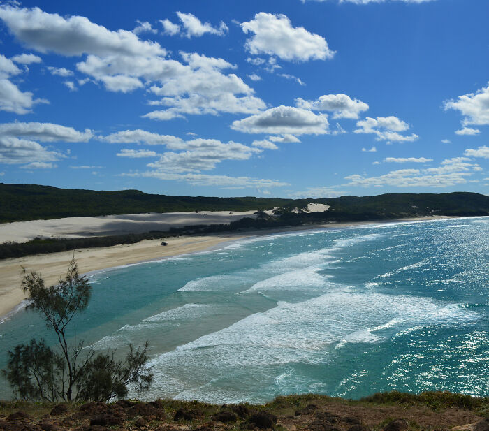 Coastal landscape with waves and sandy beach near location where backpacker was found surrounded by dingoes.