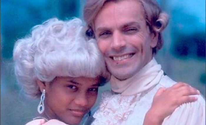 A couple dressed in historical costumes embracing, illustrating crazy things people did for love.