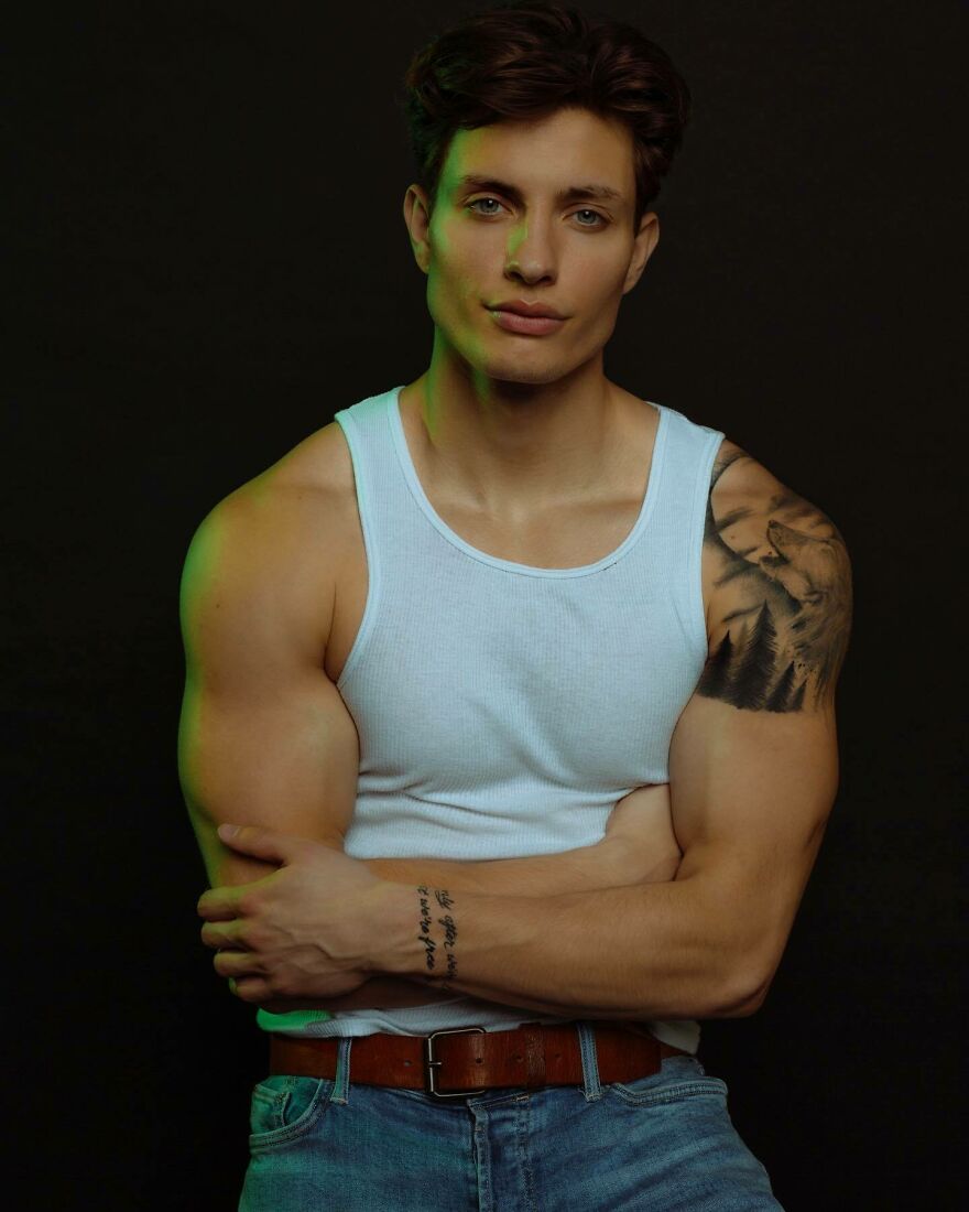 Matt Rife posing confidently in a white tank top and jeans, addressing plastic surgery rumors and transformations. Matt Rife posing confidently in a white tank top and jeans, addressing plastic surgery rumors and transformations.