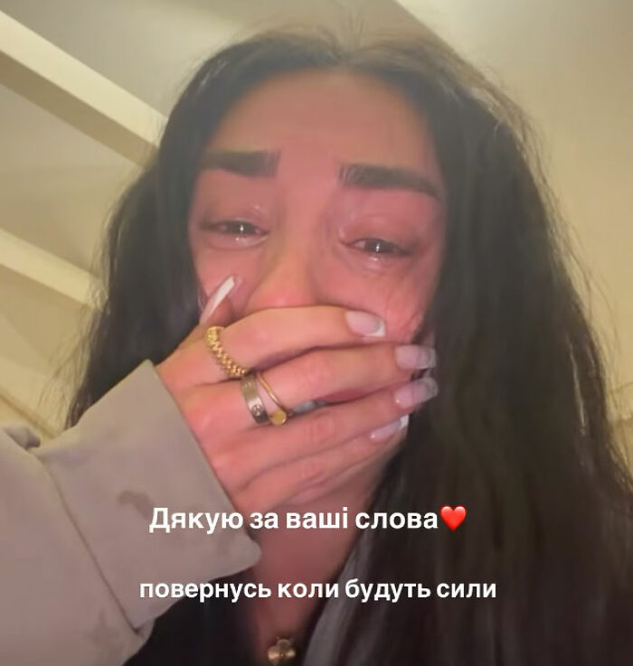 Woman with tears in her eyes covering her mouth, reflecting emotional response to police disturbing update in Bali case.