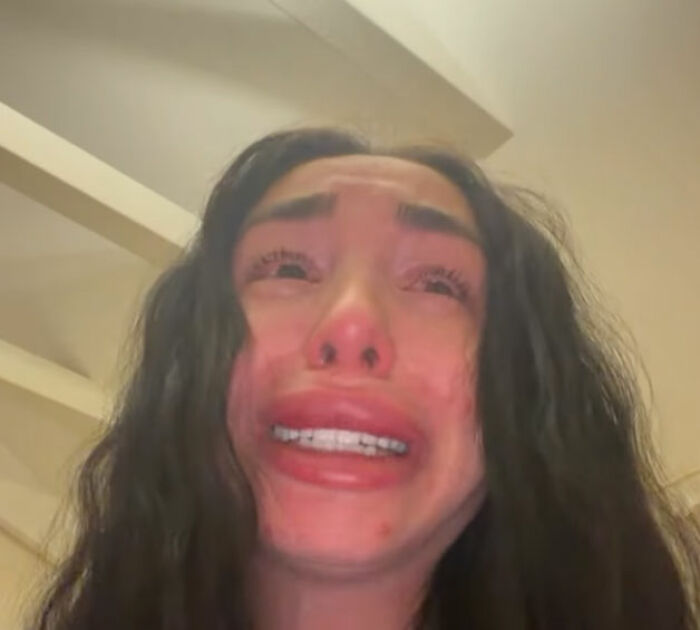 Distressed young woman with long dark hair crying, related to police update on horrifying discovery linked to wealthy businessman's son.