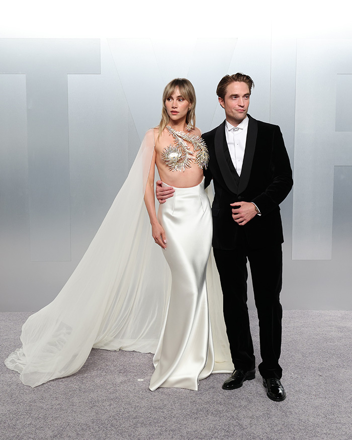 Couple posing in striking and controversial outfits at Oscars afterparties, showcasing notable fashion fails and absurd looks.
