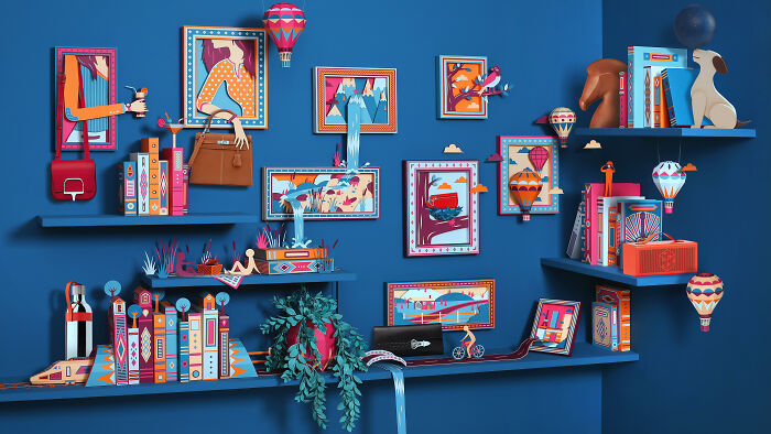 Handcrafted paper art by French artist duo creating intricate, colorful, and dynamic paper worlds showcased on blue shelves.