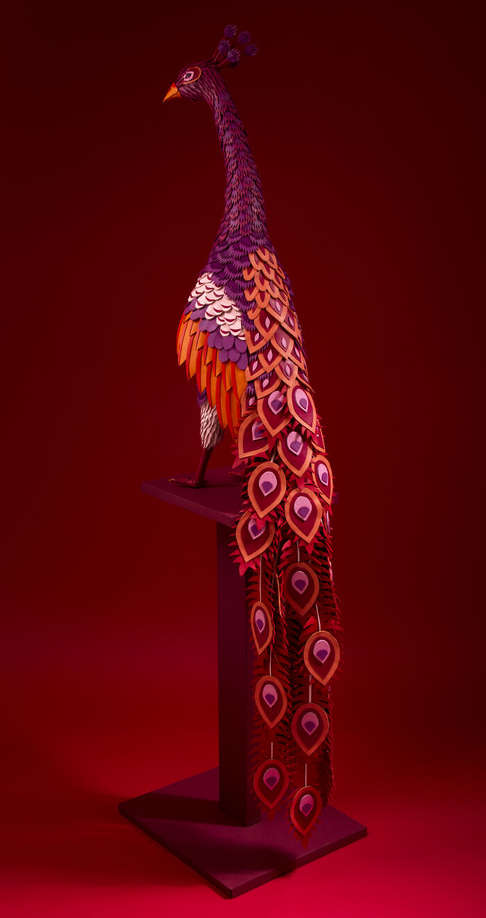 Vibrant handcrafted paper peacock sculpture with detailed feathers by French artist duo showcasing incredible paper art.