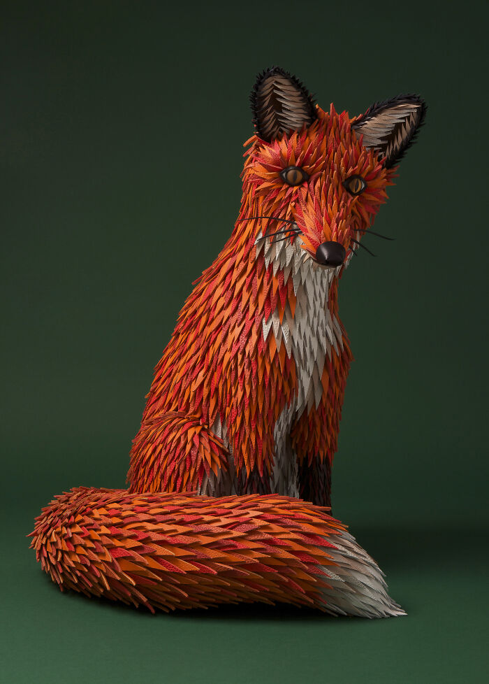 Handcrafted paper fox sculpture by French artist duo, showcasing intricate details and vibrant orange hues.