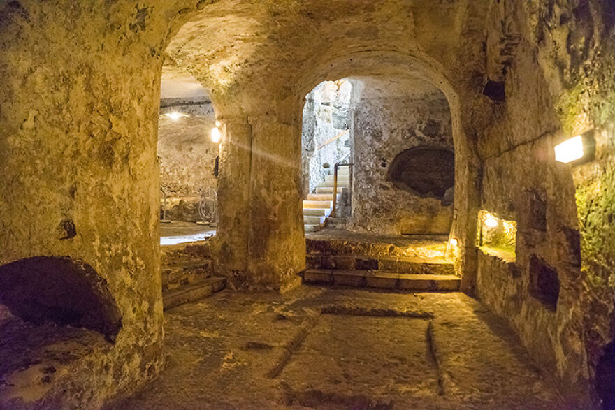 Ancient underground city interior with stone walls and archways, highlighting the fascinating reasons people built them.