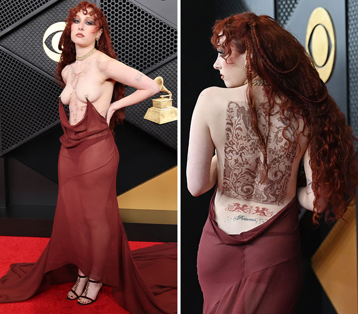 Red-haired woman wearing a sheer maroon dress with an elaborate back tattoo at a 2026 award season fashion event.