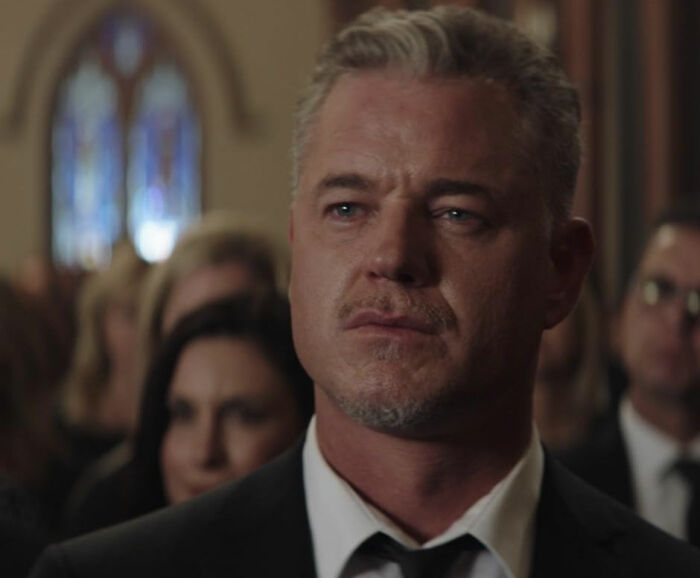 Eric Dane in a suit at a formal event, with a serious expression, related to Oscars in memoriam tribute controversy.