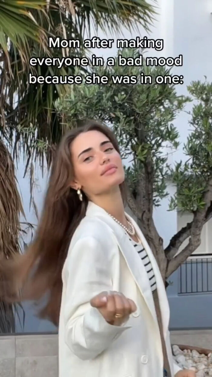 Young woman flipping hair outside with text about mom in a bad mood, meme illustrating entertaining memes to function properly.