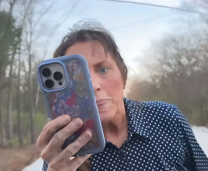 Michelle Duggar in a heated confrontation outdoors, holding a smartphone with an intense expression.