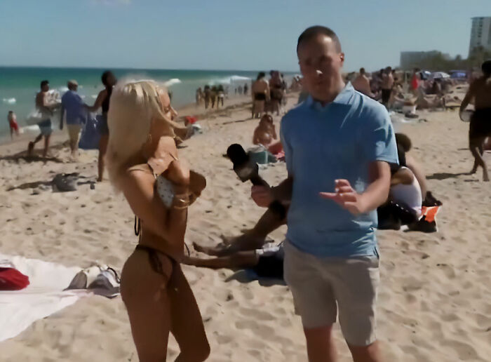 Reporter interviewing a spring breaker on a crowded beach, capturing responses about the news in a viral video.