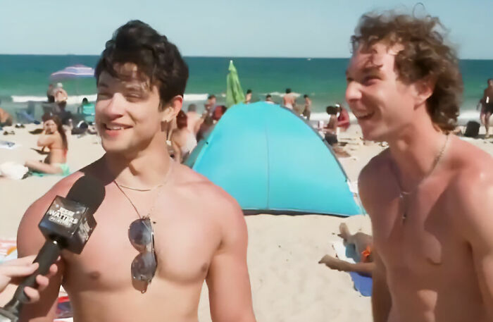 Two shirtless young men on a beach being interviewed in a viral video about spring breakers and the news.