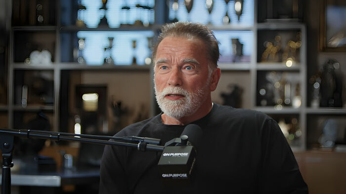 Man with gray beard speaking into microphone during a podcast about custom $2.5 million mobile mansion celebrity requests.