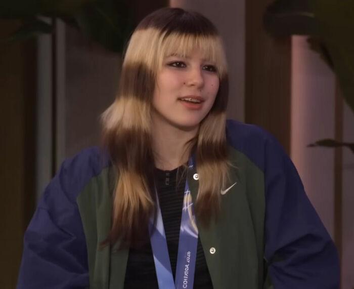 Alysa Liu wearing a medal and jacket, speaking in an indoor setting after dropping out of World Championships.