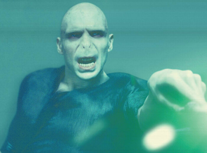 Villainous character Voldemort from Harry Potter reaching forward with a menacing expression in a dark setting. Villainous character Voldemort from Harry Potter reaching forward with a menacing expression in a dark setting.