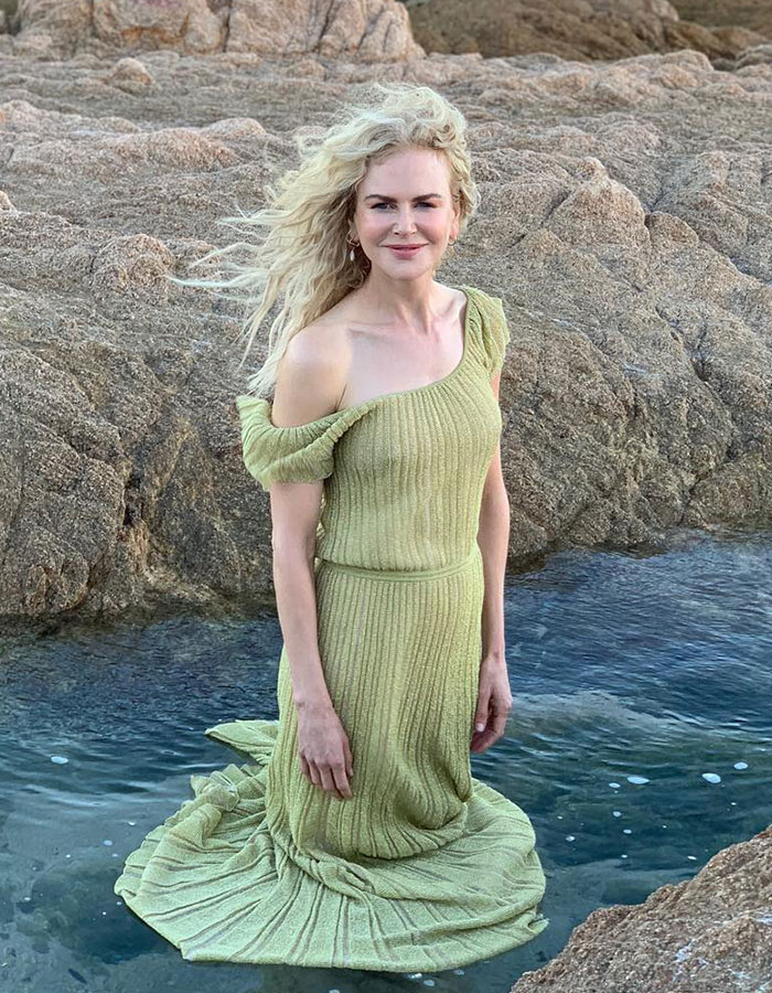 Nicole Kidman posing near rocky water, wearing a green dress, fans notice odd details in her appearance.