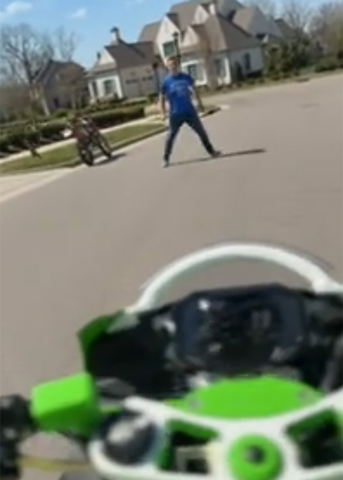Man in blue shirt confronting someone on a street, captured from a bodycam footage during neighbor confrontation incident.