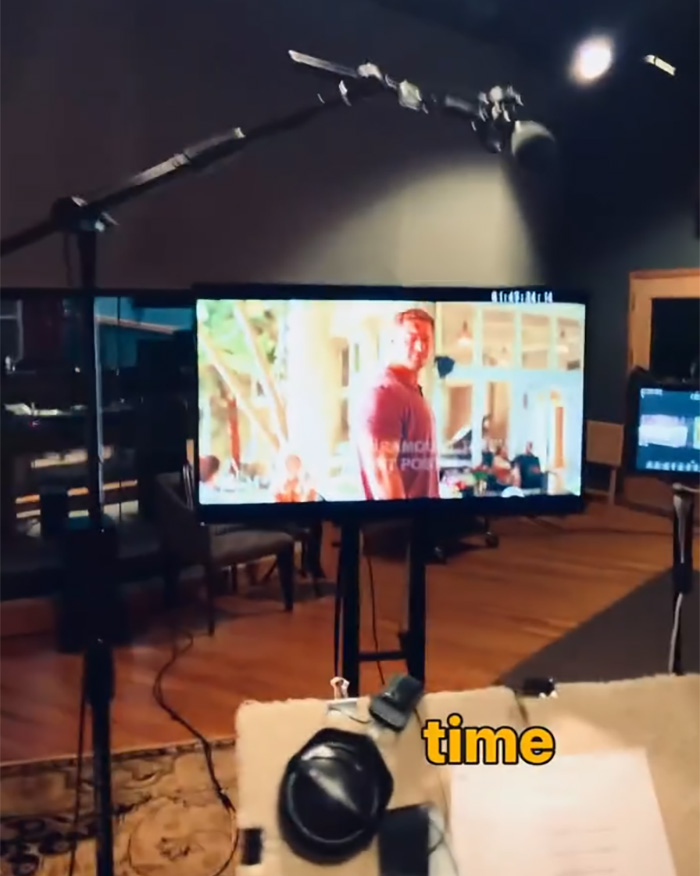 Behind the scenes of Alan Ritchson speaking out during a filmed segment in a studio setting with equipment visible.
