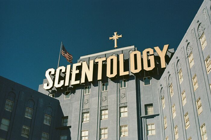 Scientology building with large sign and American flag, representing one of the shaky industries at risk of collapse.