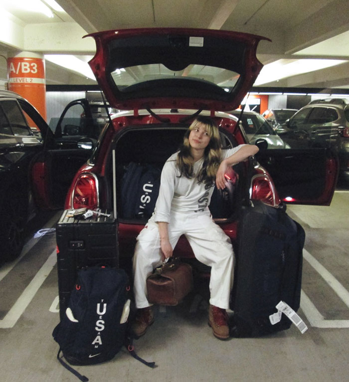 Olympic hero Alysa Liu sitting by car trunk with luggage, reflecting on her decision to drop out of World Championships.