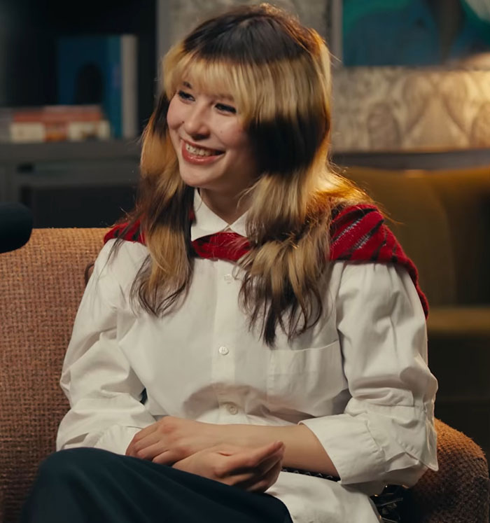 Alysa Liu, Olympic hero, smiling and seated during an interview revealing why she dropped out of World Championships.