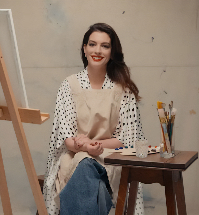 Anne Hathaway sitting with paintbrushes and palette, reflecting on appearance after Oscars look discussions.