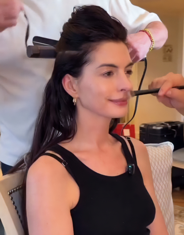 Anne Hathaway getting makeup applied while preparing for an event after fans noticed something off about her Oscars look.