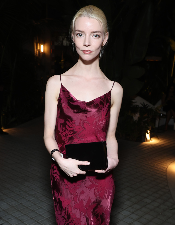 Anya Taylor-Joy at a pre-Oscars dinner, wearing a burgundy dress and holding a black clutch, sparking Hollywood trend concerns.