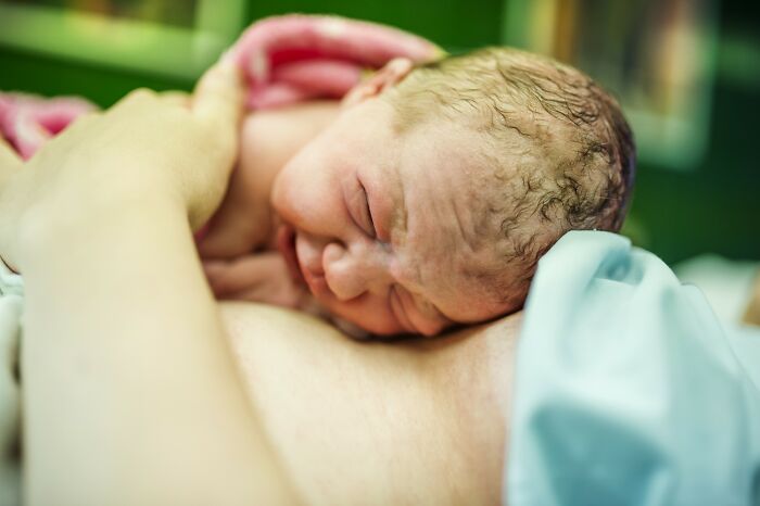 Newborn baby resting on mother's chest, highlighting the complexity and wonders of the human body design.