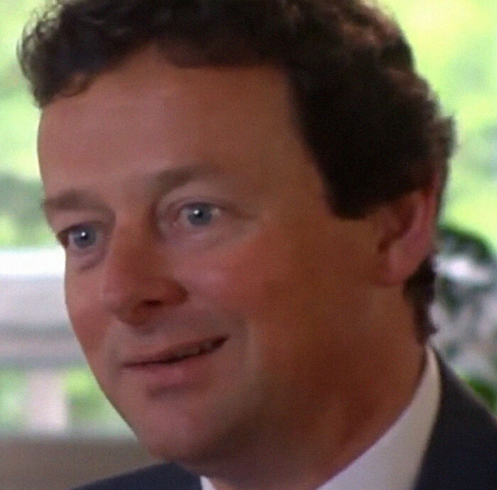 Man with curly hair and blue eyes smiling in an indoor setting, illustrating epic PR fails in moments of disbelief.