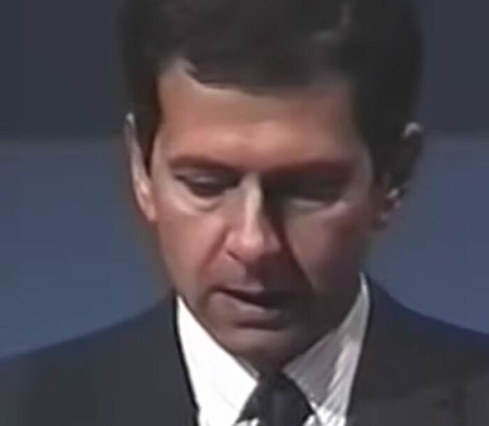 Man in a dark suit and tie looking down during a speech, illustrating epic PR fails and communication challenges.