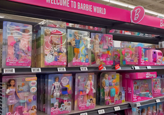 Prateleiras de bonecas Barbie em embalagens expostas em loja de brinquedos com foco em itens escondidos dentro das embalagens da Barbie. Prateleiras de bonecas Barbie em embalagens expostas em loja de brinquedos com foco em itens escondidos dentro das embalagens da Barbie.