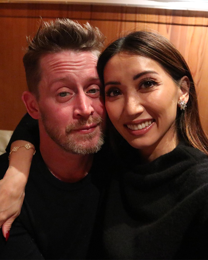 Brenda Song and Macaulay Culkin smiling closely together, highlighting airline separation during nightmare flight with kids. Brenda Song and Macaulay Culkin smiling closely together, highlighting airline separation during nightmare flight with kids.