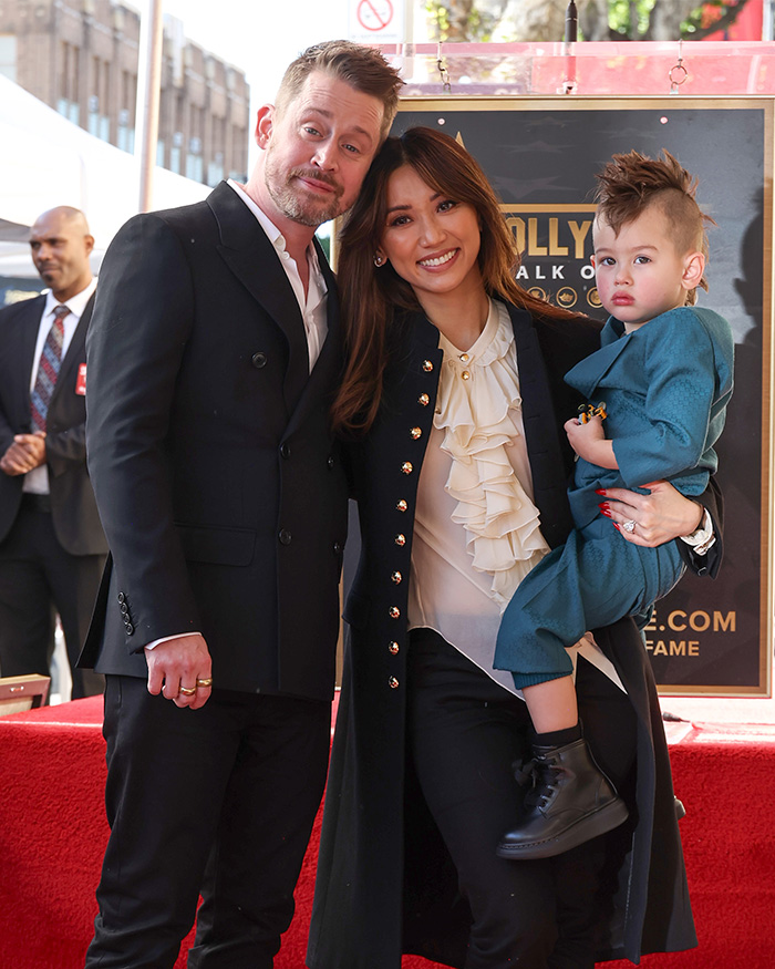 Brenda Song and Macaulay Culkin posing with their child during public event amid airline flight controversy. Brenda Song and Macaulay Culkin posing with their child during public event amid airline flight controversy.
