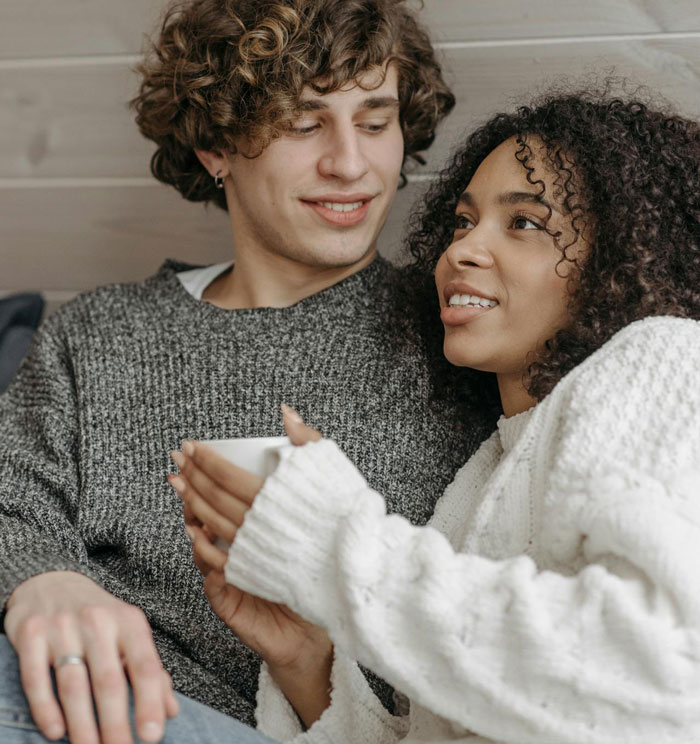Young couple sitting close, with guy approving an outfit that could cause sister&rsquo;s wedding drama.