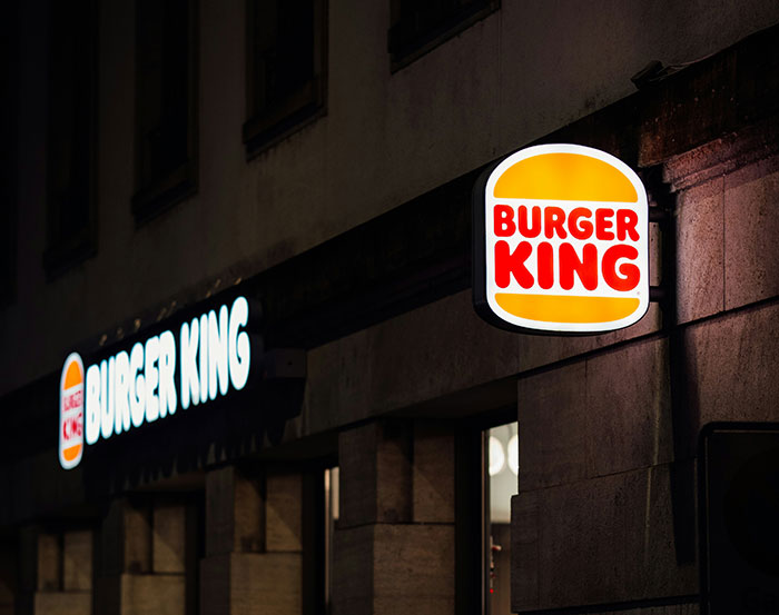 Burger King restaurant exterior with illuminated signage at night, illustrating a cringe moment at the 2026 Oscars.